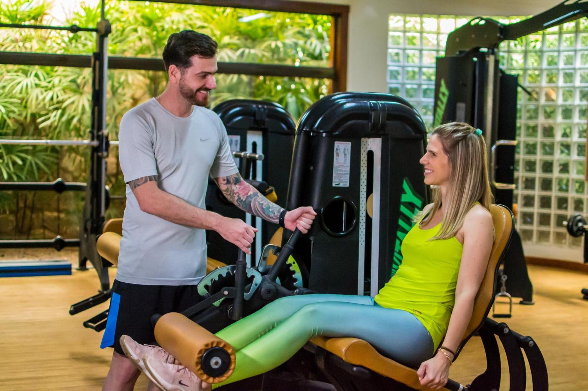 Blue Tree Thermas de Lins Exterior foto Personal trainer assisting a woman on a leg press machine